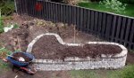 Raised herb garden wall 11 about to shovel on second load of compost (05-10) -small.JPG